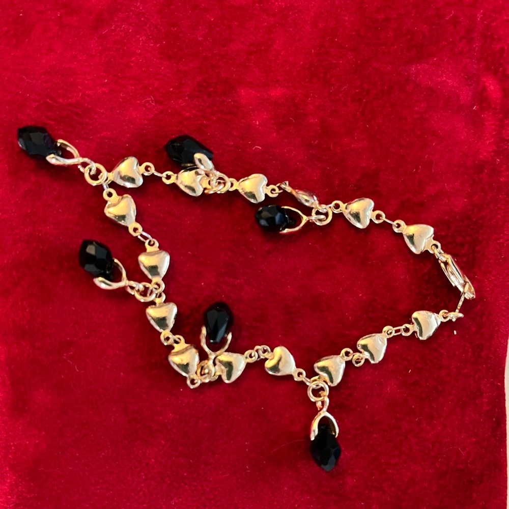 Yellow gold bracelet with black gem charms. Marked 14k.